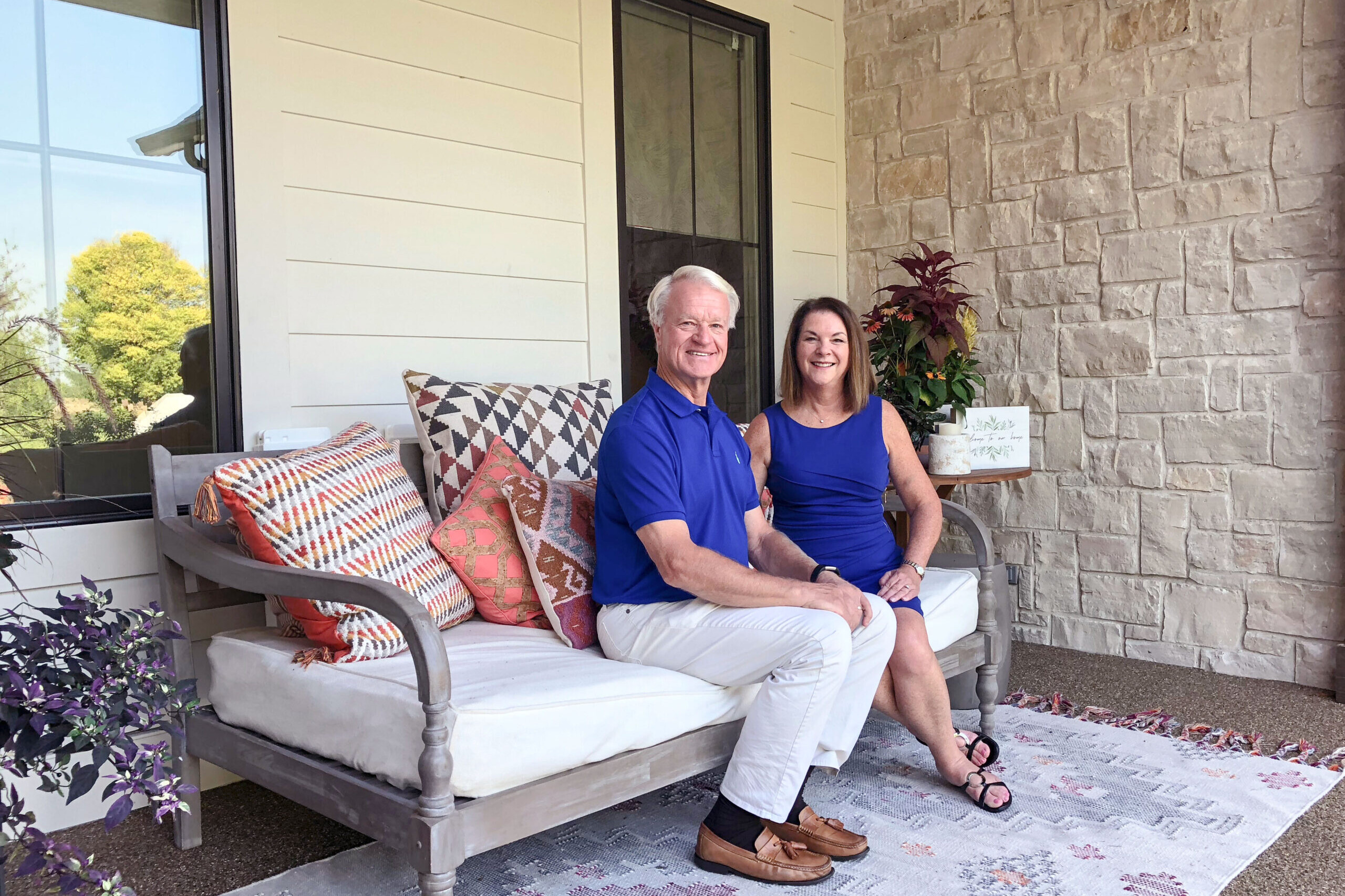 A man and woman sitting on a porch of their new custom home near Indianapolis, built by a top-rated custom home builder in Fishers, Indiana.