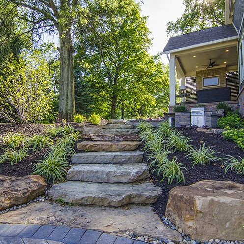 A stone walkway leading to a front yard in a custom home community.