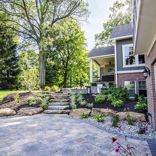 A backyard with a stone walkway and patio, perfect for a custom home in Carmel, Indiana.