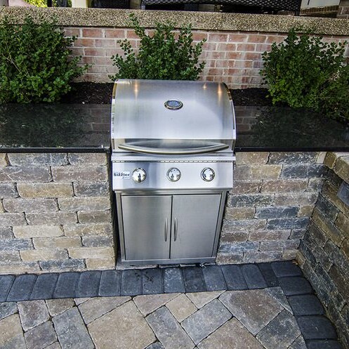 An outdoor kitchen with a grill and brick pavers, perfect for your new home in Carmel Indiana.