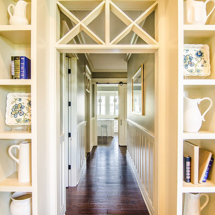 A luxury hallway with elegant bookshelves and decorative vases.