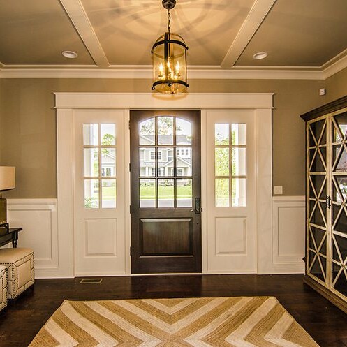 A new home entryway featuring a chevron rug and a door.