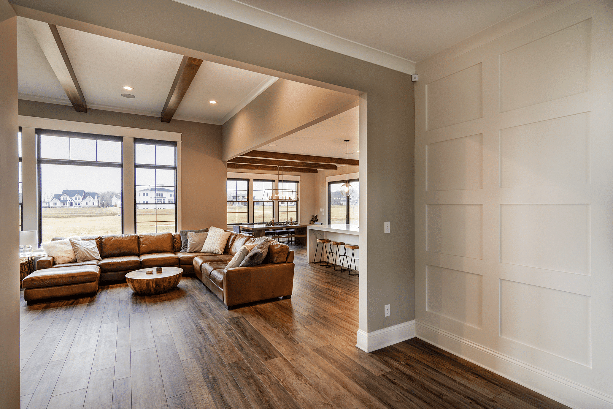 A custom built living room adorned with beautiful hardwood floors and a spacious window, nestled in the heart of Indianapolis, Indiana.