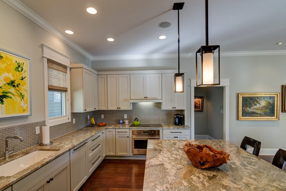 A kitchen with white cabinets and marble counter tops in a custom home built by Custom Home Builder Fishers Indiana.