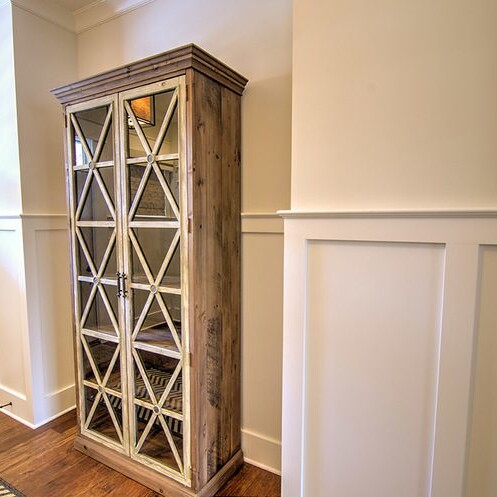 A large bookcase in a hallway with hardwood floors, complementing the luxury design of a custom-built home in Westfield Indiana.