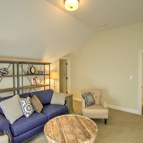 A living room with a blue couch and a coffee table in a new home for sale in Carmel Indiana.