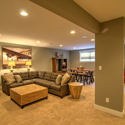 A living room with a couch, tv, and stairs, designed and built by a luxury custom home builder in Indianapolis Indiana.