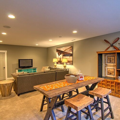 A living room with a TV and bar stools in a new home for sale in Carmel Indiana.