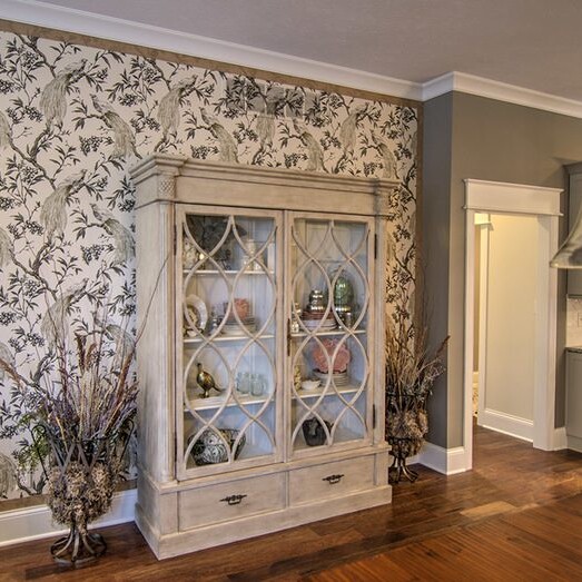 A luxury kitchen with a china cabinet and wallpaper, designed by a custom home builder in Carmel Indiana.