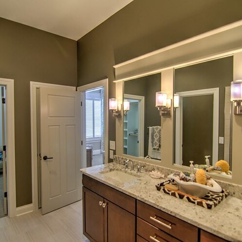A luxury bathroom with two sinks, a mirror, and custom features.