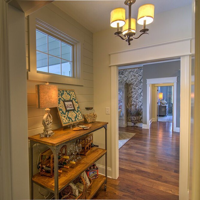 A hallway with hardwood floors and a light fixture in a custom home in Carmel, Indiana.