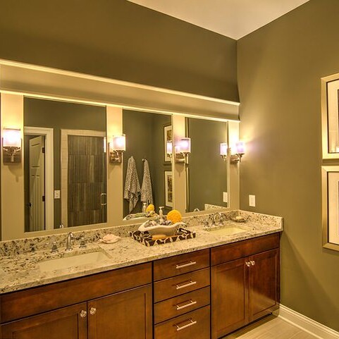A bathroom with two sinks, a mirror and custom features.