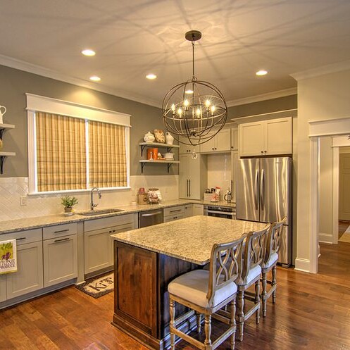 A kitchen with a center island and hardwood floors.