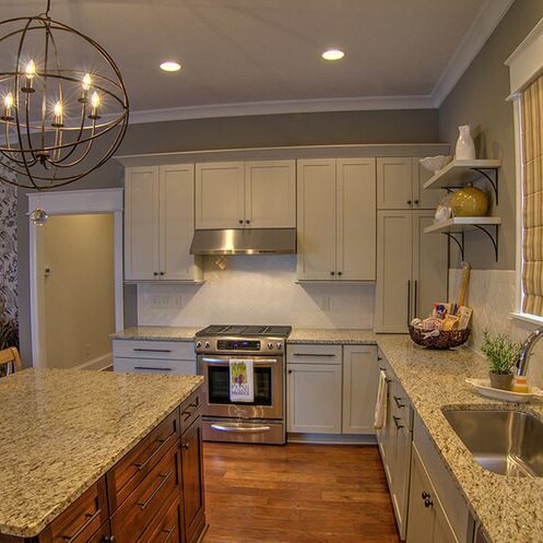 A kitchen with white cabinets and granite counter tops, built by a luxury custom home builder in Carmel Indiana.