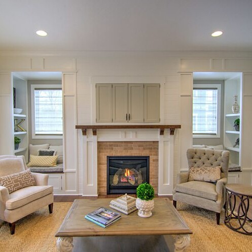 A living room with white furniture and a fireplace, designed by a Custom Home Builder in Carmel Indiana.