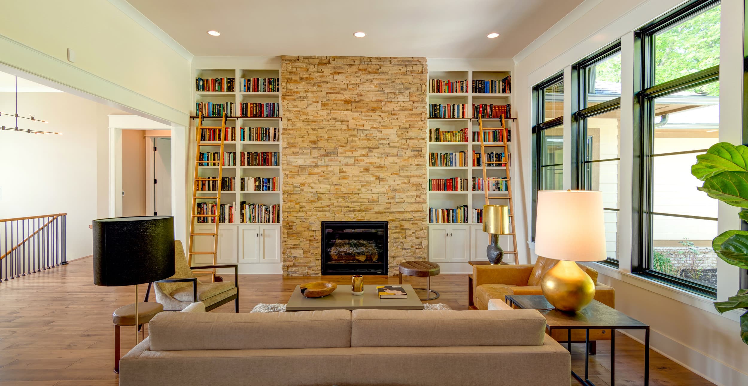 A living room with a fireplace and bookshelves in a custom home builder in Fishers, Indiana.