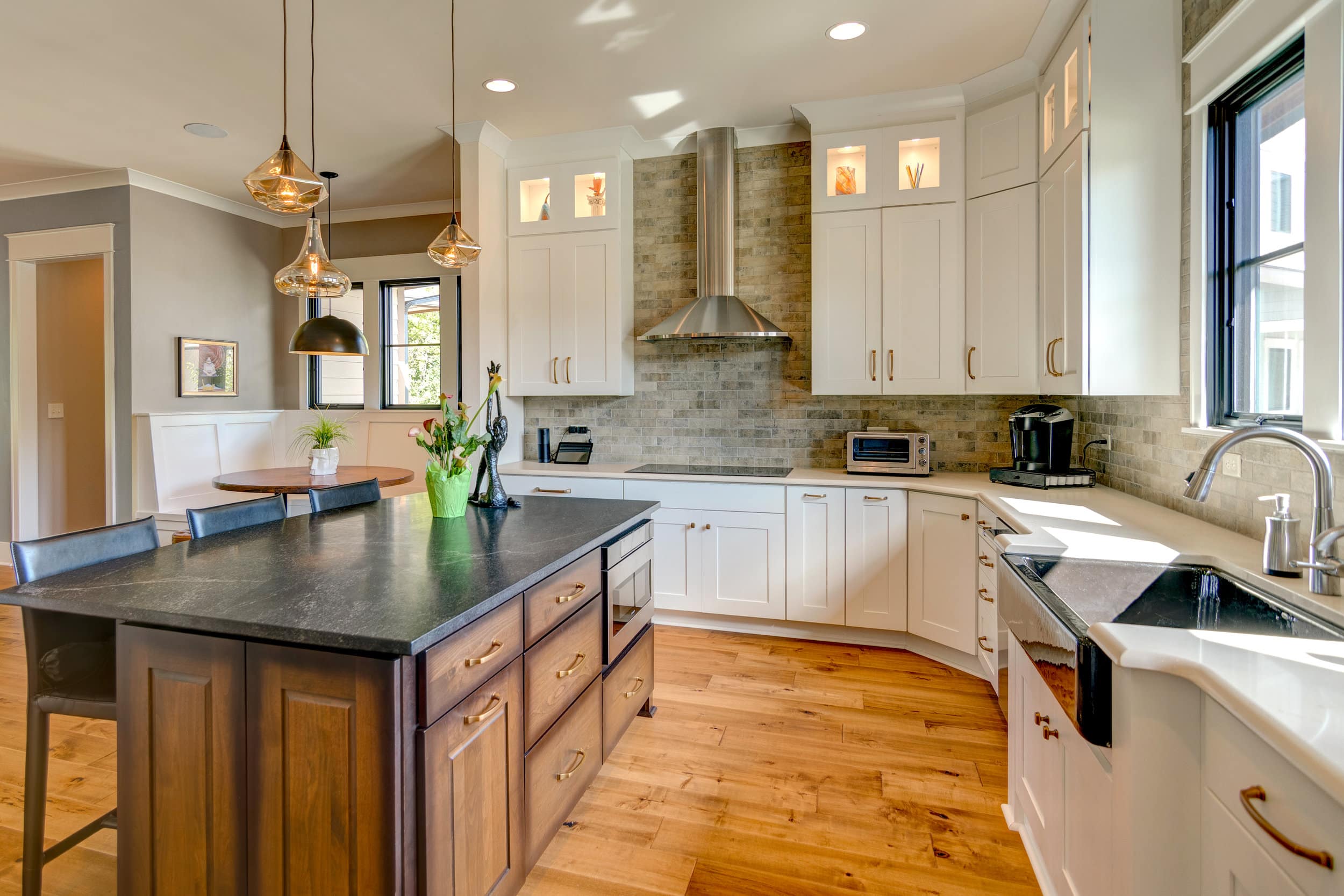 A kitchen with hardwood floors and a center island, designed by a custom home builder in Fishers Indiana.