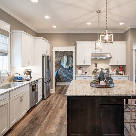 A kitchen with hardwood floors and a center island, built by a custom home builder in Carmel Indiana.