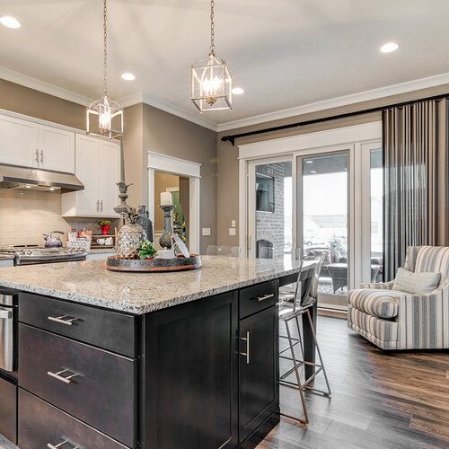 A luxury custom home builder in Westfield Indiana presents a kitchen with hardwood floors and a center island, located in new homes for sale in Carmel Indiana and Fishers Indiana.