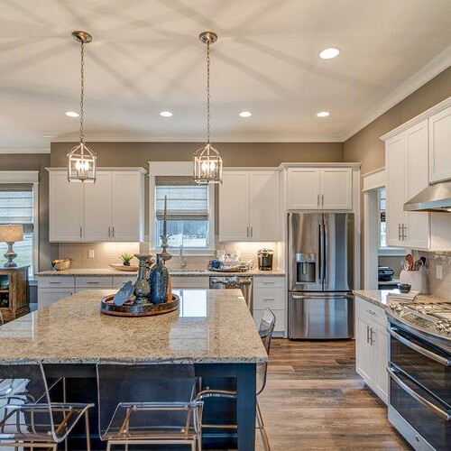A luxurious kitchen with granite countertops and stainless steel appliances, designed and built by a top custom home builder in Westfield, Indiana.