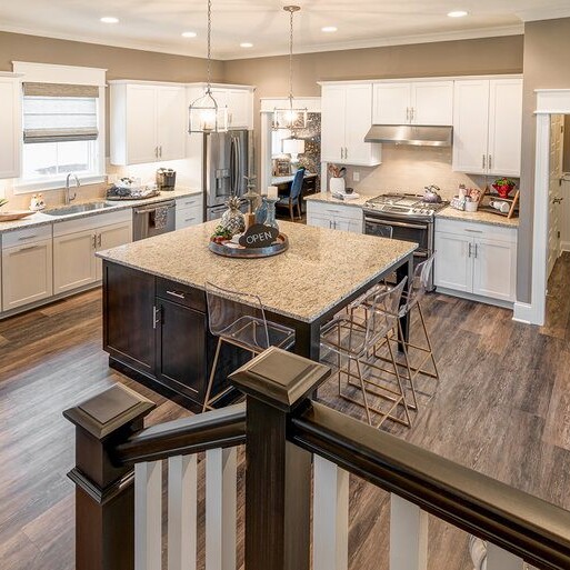 A kitchen with white cabinets and hardwood floors in a luxury custom home built by a custom home builder in Westfield Indiana.