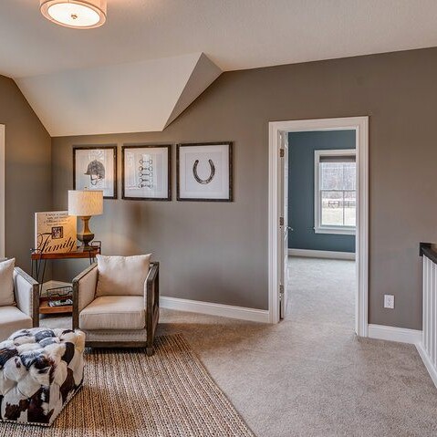 A living room with gray walls and a cowhide rug in a luxury custom home.