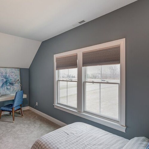 A luxurious bedroom with elegant gray walls and a stylish desk.