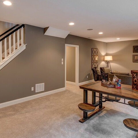 A basement with stairs and a table in a new home for sale in Carmel Indiana.