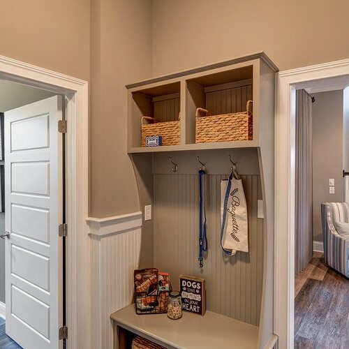 A mudroom with a coat rack and coat hooks, designed by a custom home builder in Carmel Indiana.