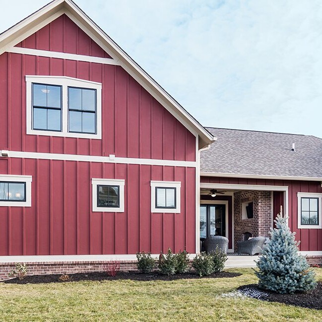 A red and white house with a white trim, available as a custom home in Carmel Indiana.