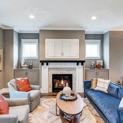 A living room with blue couches and a fireplace, located in Carmel Indiana.