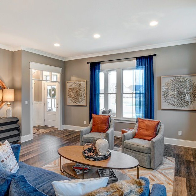 A luxurious living room in a custom home, featuring elegant blue couches and a cozy fireplace.