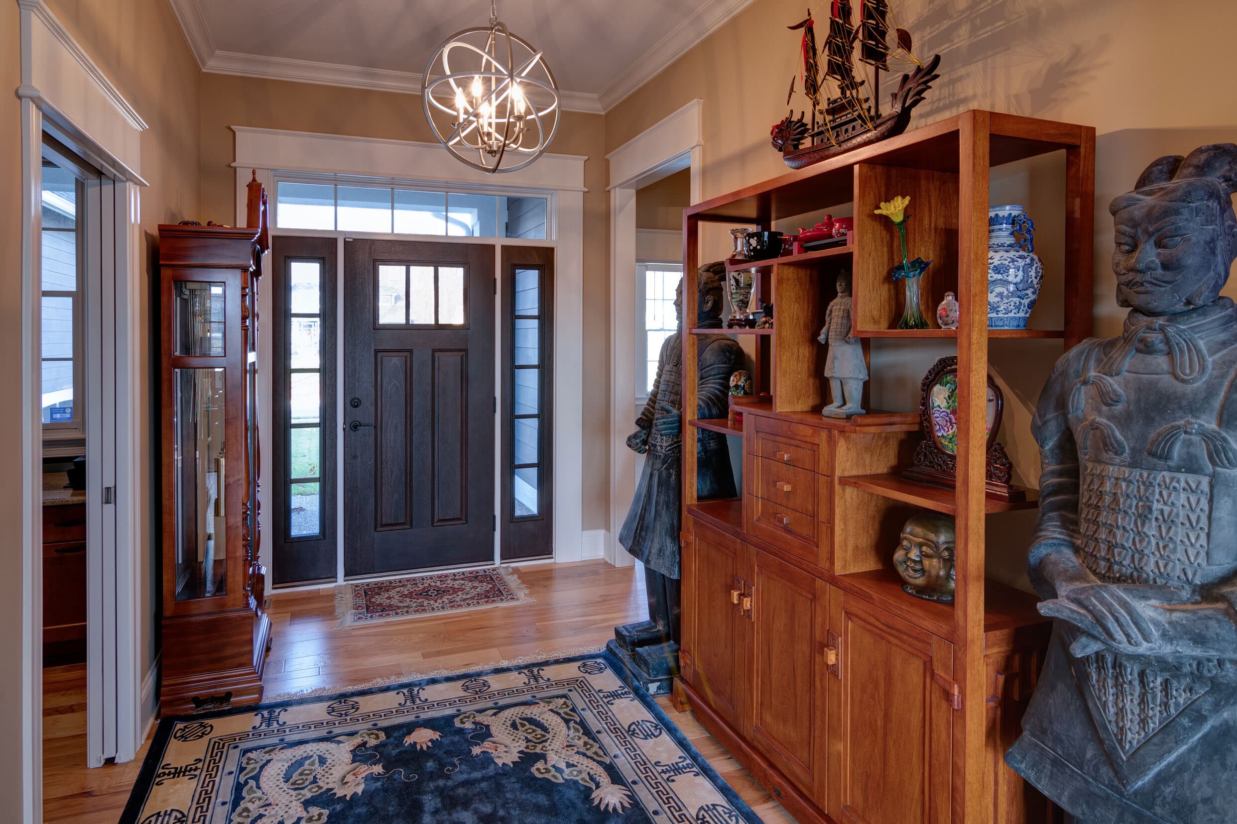 A hallway with a door and a statue, featuring elegant custom homes in Westfield Indiana.