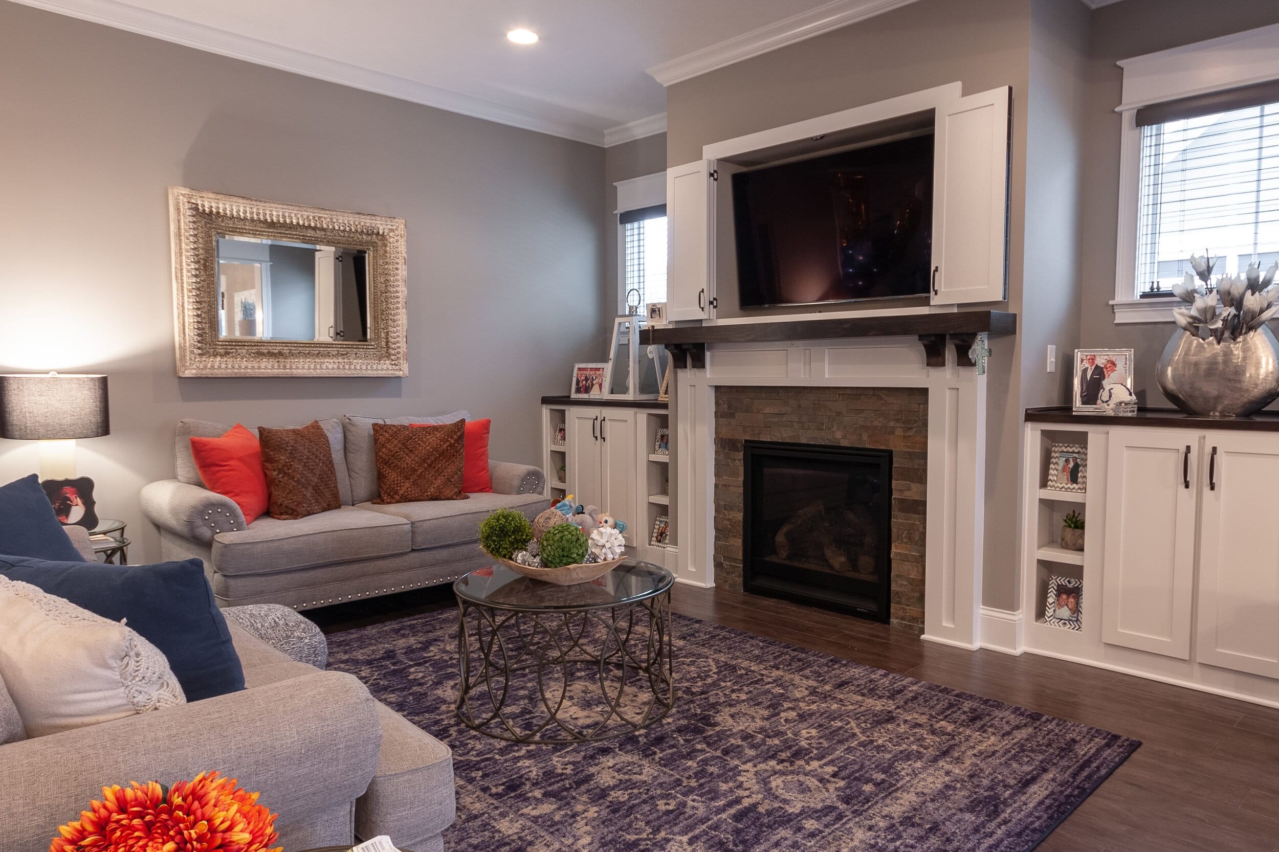 A cozy living room with couches and a fireplace in a custom-built home.