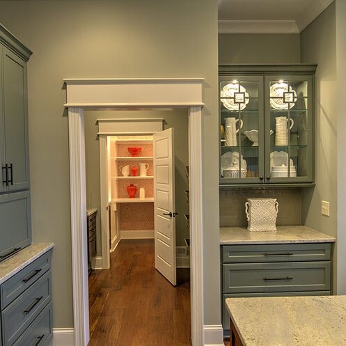 A luxury kitchen with gray cabinets and granite counter tops in a custom home.