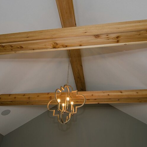 A room with wooden beams and a chandelier in Carmel, Indiana.