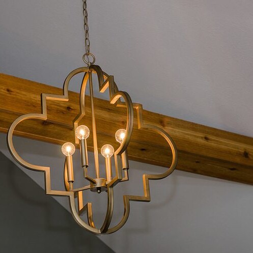 A gold chandelier hanging from a wooden ceiling in one of Fishers Indiana Custom Homes.