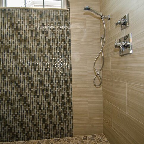 A luxurious tiled shower with a glass door and meticulously crafted tiled walls.