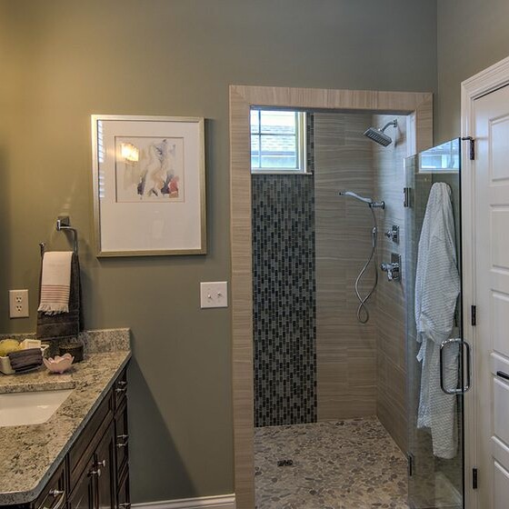 A custom home with a walk-in shower and granite countertops.