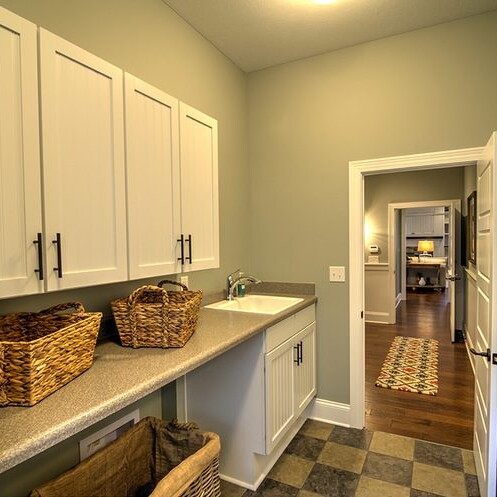 A laundry room with a sink and baskets in a new home for sale in Carmel Indiana.