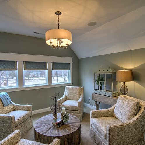 A living room with two chairs and a table in a luxury custom home in Carmel Indiana.