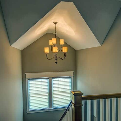 A luxurious stairway with a beautiful light fixture.