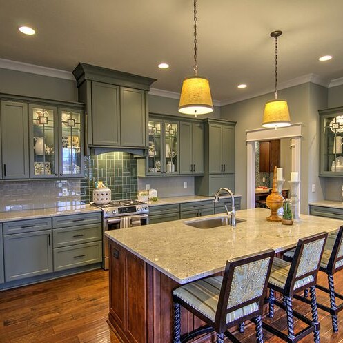 A kitchen with a center island and bar stools in a luxury custom home built in Carmel, Indiana.