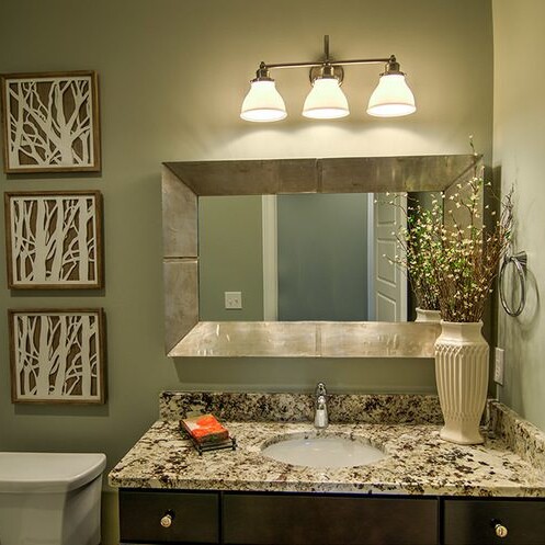 A bathroom with granite counter tops and a mirror, featured in luxury custom homes for sale in Carmel Indiana.