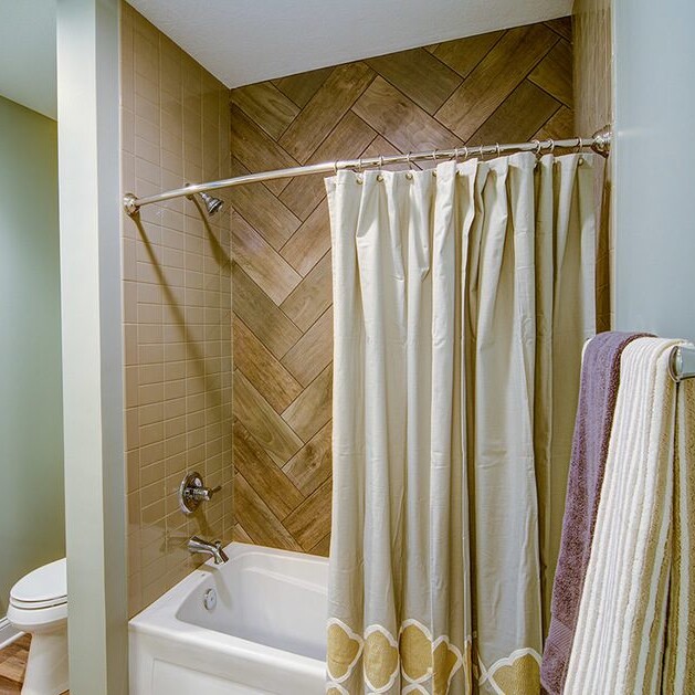 A bathroom with a herringbone tile floor, perfect for luxury custom homes in Carmel Indiana.