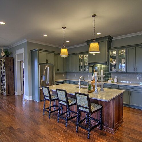 A kitchen with a center island and bar stools, designed by a Custom Home Builder in Carmel Indiana.