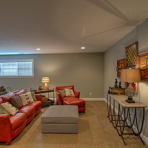 A living room with red couches and a coffee table in a luxury custom home.