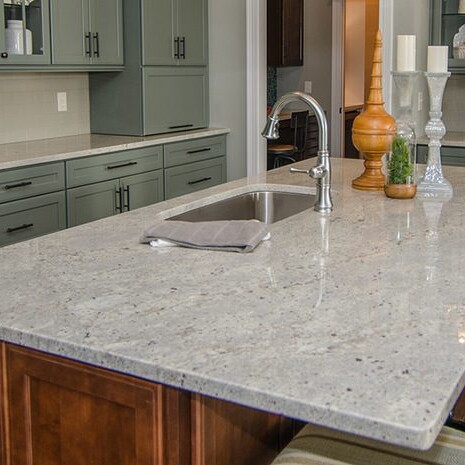 A luxury kitchen with granite counter tops and green cabinets, built by a custom home builder in Carmel Indiana.