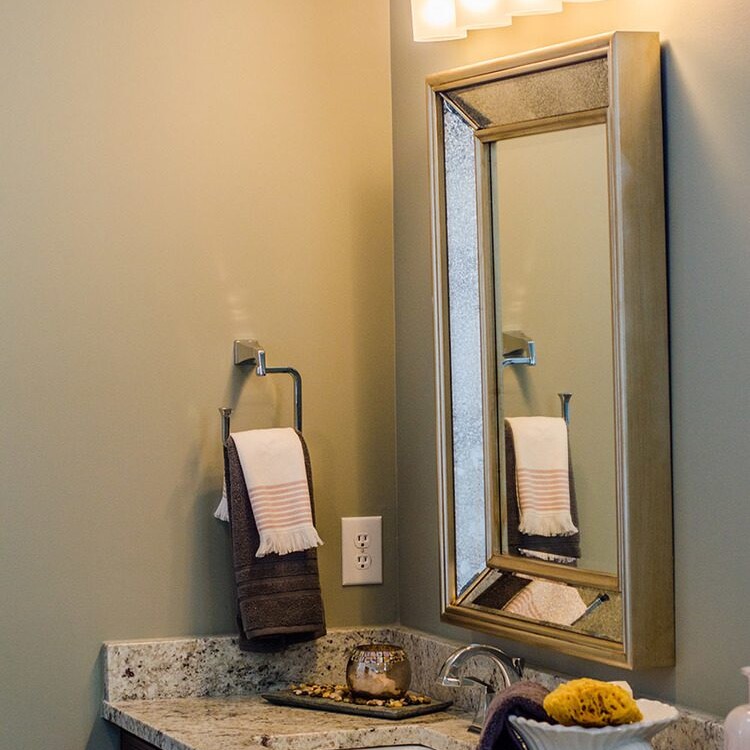 A bathroom with a sink and mirror, designed by a luxury custom home builder in Carmel Indiana.