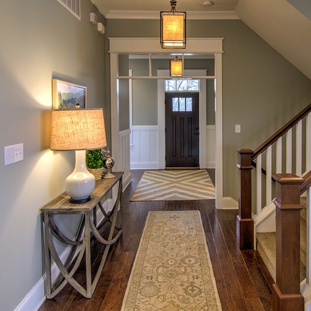 A hallway with hardwood floors and a lamp in a custom-built home in Carmel, Indiana.